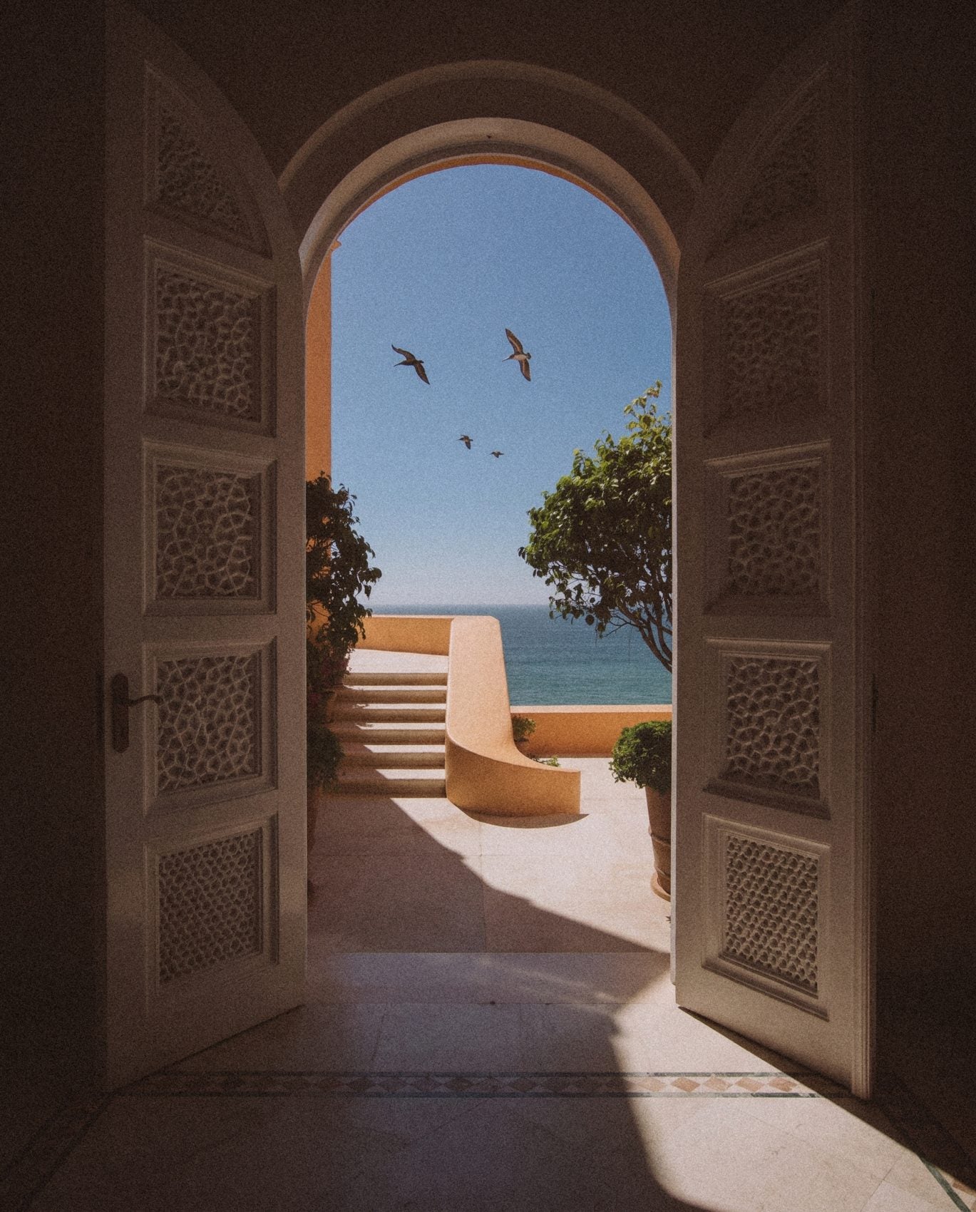 AI-directed EVARAE image, an arched doorway open to the sea