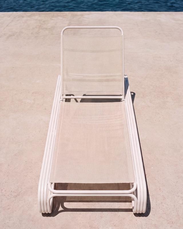 Empty location: a white lounger on pale stone